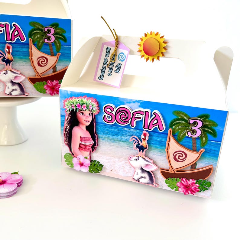 May include: White party favor boxes with a beach theme. Each box features a cartoon image of a girl, a boat, a pig, and a rooster. The boxes have the name "Sofia" and the number "3" on them. A tag says "Gracias por venir a mi fiesta Sofia".