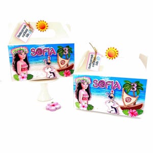 May include: Two white party favor boxes with a colorful design featuring a cartoon girl, a rooster, and a sailboat. The boxes have the name "Sofia" and the number "3" on them. A small sun and a tag are attached.