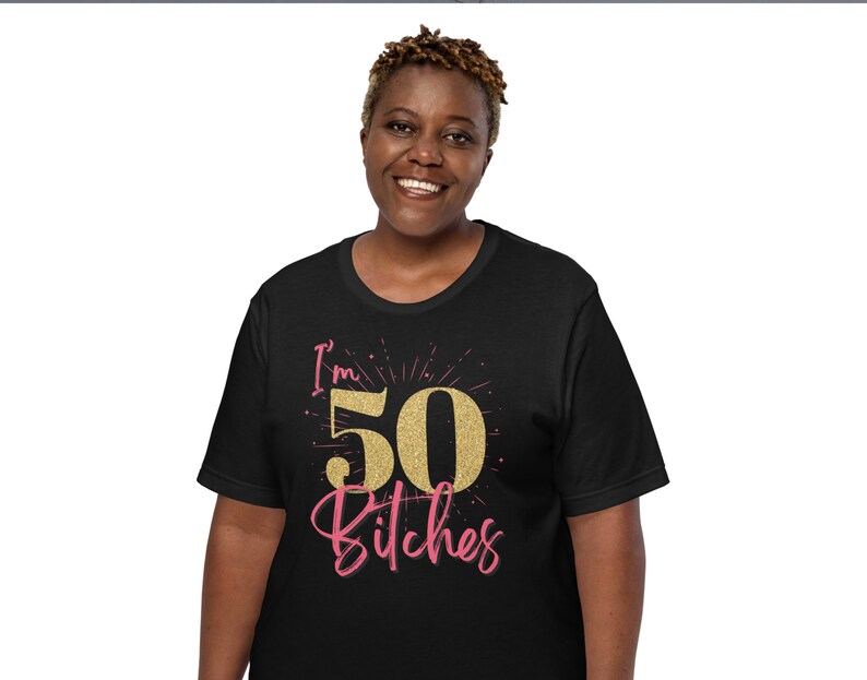 Puede incluir: Camiseta negra con un gr&aacute;fico de "I'm 50 Bitches" en purpurina dorada.