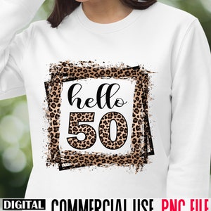 May include: A white sweatshirt with a leopard print design featuring the text "hello 50" in a black frame.