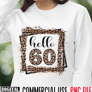 May include: A white sweatshirt with a leopard print design featuring the text "hello 60" in a black frame.
