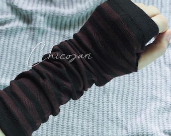 May include: Black and burgundy striped fingerless gloves. The gloves are made of a soft, ribbed material and cover the forearm and hand, leaving the fingers exposed. The gloves are designed to keep the hands warm while allowing for dexterity.