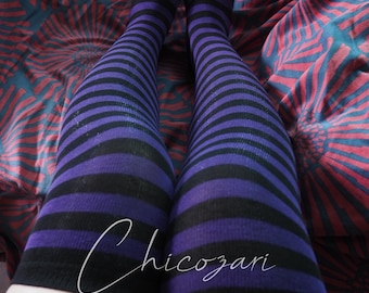 May include: A pair of over-the-knee socks featuring horizontal stripes in alternating shades of deep purple and black. The socks extend from the upper thigh down to the toes, covering the legs completely. The word Chicozari is written in white script.