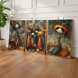 May include: A triptych of framed art prints depicting Halloween-themed characters. The illustrations feature figures with pumpkin heads and witch hats, set against a backdrop of swirling clouds and pumpkins. The colour scheme includes orange, black, and gold.