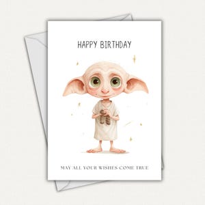 May include: A white greeting card with the text "HAPPY BIRTHDAY" and "MAY ALL YOUR WISHES COME TRUE". The card features a watercolor illustration of a character with large ears and green eyes, holding a pair of socks.