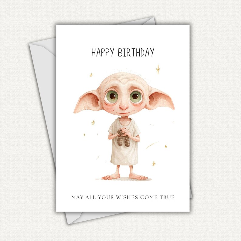 May include: A white greeting card with the text "HAPPY BIRTHDAY" and "MAY ALL YOUR WISHES COME TRUE". The card features a watercolor illustration of a character with large ears and green eyes, holding a pair of socks.