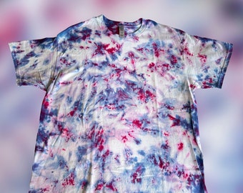 May include: A tie-dye t-shirt with a white background and blue and red dye in a swirling pattern.
