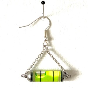 May include: Silver dangle earrings with a green level bubble attached to a silver chain.