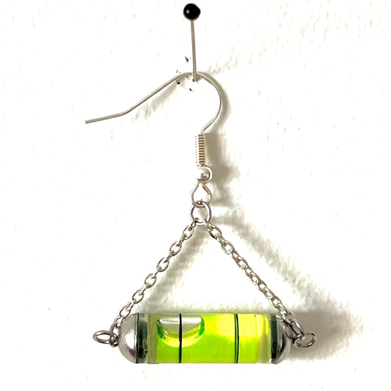 May include: Silver dangle earrings with a green level bubble attached to a silver chain.
