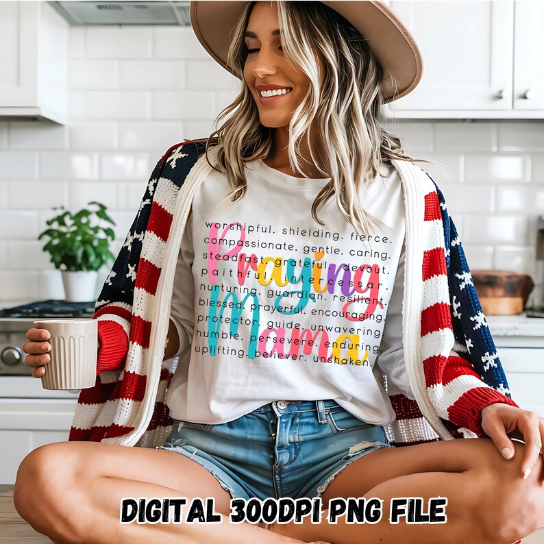 Peut inclure: Un t-shirt blanc avec un design d'art de mots color&eacute; qui &eacute;pelle "mama" avec une liste d'adjectifs positifs d&eacute;crivant une m&egrave;re. Le texte se lit comme suit&nbsp;:&nbsp;worshipful, shielding, fierce, compassionate, gentle, caring, steadfast, grateful, devout, faithful, intercessor, nurturing, guardian, resilient, blessed, prayerful, encouraging, protector, guide, unwavering, humble, persevere, enduring, uplifting, believer, unshaken. Le t-shirt est port&eacute; par une personne portant un cardigan rouge, blanc et bleu et un short en jean. L'image comprend le texte "DIGITAL 300DPI PNG FILE".