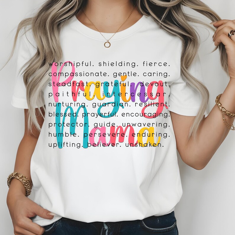 Peut inclure: T-shirt blanc avec le mot "Praying Mama" en lettres color&eacute;es. Le mot est d&eacute;fini avec des attributs positifs comme "respectueux, protecteur, f&eacute;roce, compatissant, doux, attentionn&eacute;, ferme, reconnaissant, d&eacute;vou&eacute;, fid&egrave;le, intercesseur, nourricier, gardien, r&eacute;silient, b&eacute;ni, fervent, encourageant, protecteur, guide, in&eacute;branlable, humble, pers&eacute;v&eacute;rant, durable, &eacute;difiant, croyant, in&eacute;branlable."