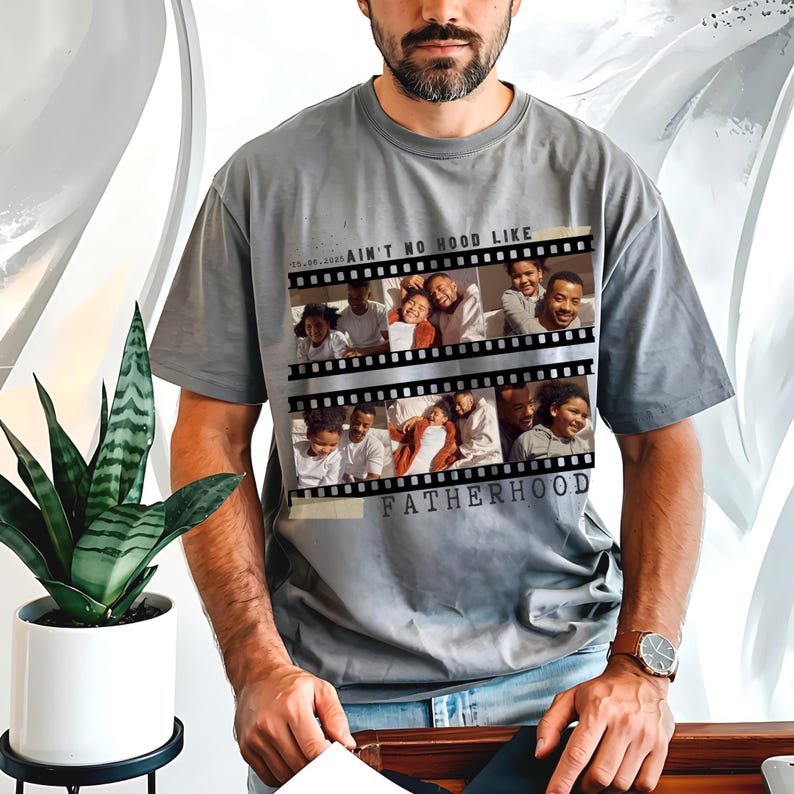 Pu&ograve; includere: T-shirt grigio con un design a striscia di pellicola con foto di famiglia e la scritta "AIN'T NO HOOD LIKE FATHERHOOD". La maglietta ha una vestibilit&agrave; ampia e maniche corte.