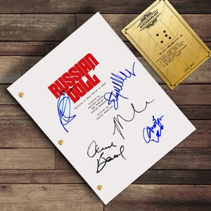 May include: A white script with the title "RUSSIAN DOLL" in red, and signatures in blue and black ink. The script is held together with gold brads. An "AUTOGRAPH KEY" card is in the upper right corner.