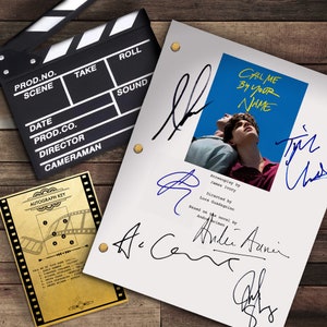 Può includere: Uno script bianco con il titolo "Call Me By Your Name" e i nomi dello sceneggiatore, del regista e dell'autore. Lo script è firmato dal regista, Luca Guadagnino, e dall'autore, Andre Aciman. Lo script è su uno sfondo di legno con una clapperboard nell'angolo.