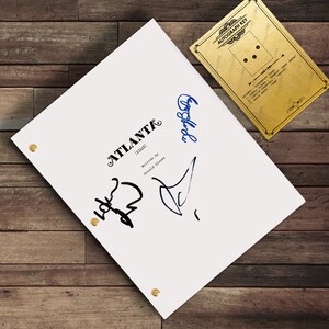 以下が含まれることがあります： 「Atlanta」の署名と「Donald Glover著」のテキストが書かれた白い台本。金色のサイン入りキーカードも付いています。台本は金のブラッドで固定され、木製の表面に置かれています。