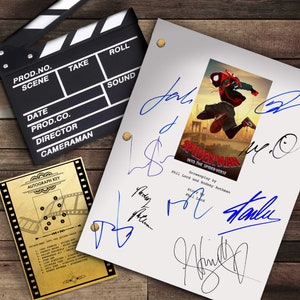 Op de afbeelding: Een filmklapper, script en handtekeningensleutel zijn gerangschikt op een houten oppervlak. Het script bevat de "Spider-Man: Into the Spider-Verse" filmposter en meerdere handtekeningen in blauwe inkt. De handtekeningensleutel is goudkleurig.