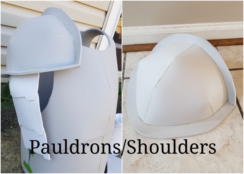 May include: Two white foam shoulder pads for a costume. The shoulder pads are shaped like a dome and have a raised edge. The text "Pauldrons/Shoulders" is written below the shoulder pads.
