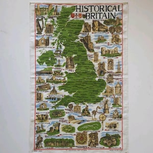 May include: A rectangular linen tea towel featuring a map of Great Britain with illustrations of historical landmarks. The towel is cream-colored with a green map and red border. The text "HISTORICAL BRITAIN" is printed at the top.