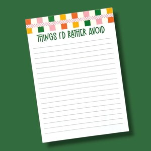 May include: A white notepad featuring horizontal lines and a top border decorated with a colorful checkered pattern of orange, green, and pink squares. The text "THINGS I'D RATHER AVOID" is printed in dark green, capital letters below the border.