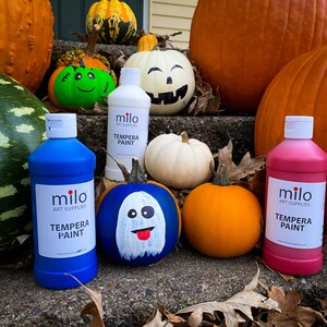以下が含まれることがあります： 青、ピンク、白の3本のミロテンペラペイントボトルと、青いカボチャに描かれた幽霊、顔のついた緑のカボチャ、白いカボチャ、オレンジ色のカボチャ。