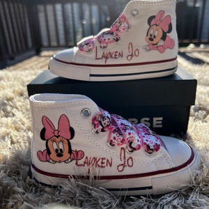 May include: White high-top sneakers with pink Minnie Mouse characters and the name "Layken Jo" written in pink glitter.