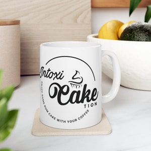 Intoxi-Cake-Tion left hand Ceramic Mug 11oz logo facing out image 1