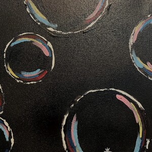 May include: Abstract painting of colourful circles on a black background. The circles are outlined in white and have multiple layers of colour, including pink, blue, yellow, and red.