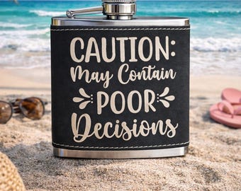 Könnte beinhalten: Edelstahl-Flachmann mit schwarzem Kunstlederbezug. Der Flachmann trägt den weißen Schriftzug "CAUTION: May Contain POOR Decisions". Der Hintergrund zeigt eine Strandszene mit Sonnenbrille, Hut und Flip-Flops.