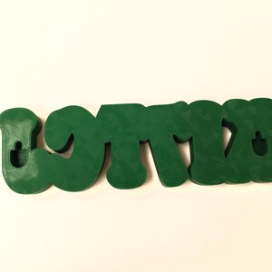 May include: Green 3D plastic letters spelling "LOTTA" with a hole in each letter for hanging.