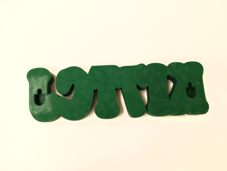 May include: Green 3D plastic letters spelling "LOTTA" with a hole in each letter for hanging.