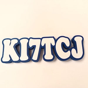 May include: White letters spelling "KITCJ" with a blue outline. The letters are in a bold, rounded font.