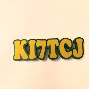 May include: A yellow and green word art piece that says "KITTCJ".