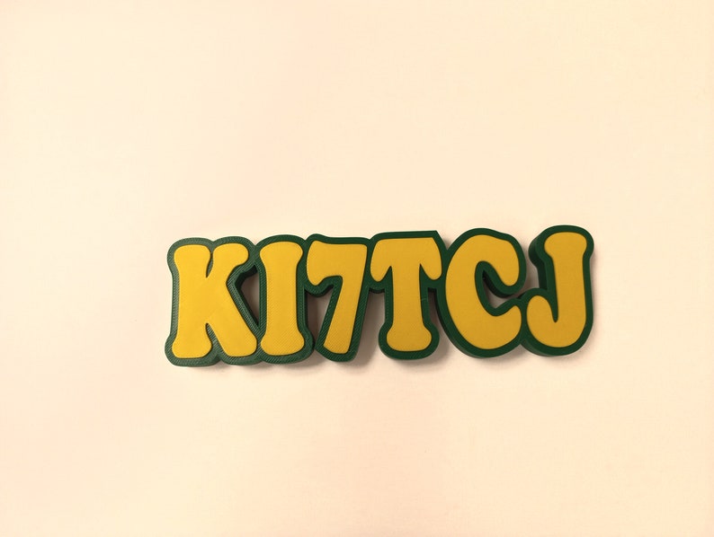 May include: A yellow and green word art piece that says "KITTCJ".