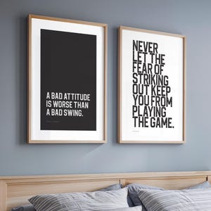 Puede incluir: Dos láminas de pared enmarcadas con marcos de madera clara. La lámina izquierda tiene un fondo negro con el texto blanco A BAD ATTITUDE IS WORSE THAN A BAD SWING. La lámina derecha tiene un fondo blanco con el texto negro NEVER LET THE FEAR OF STRIKING OUT KEEP YOU FROM PLAYING THE GAME.