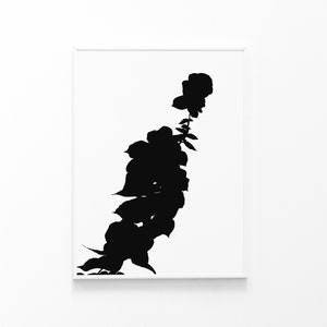 May include: A framed black and white art print featuring a stylized silhouette of a flowering plant. The artwork showcases a vertical arrangement of leaves and blooms against a white background, creating a minimalist aesthetic.