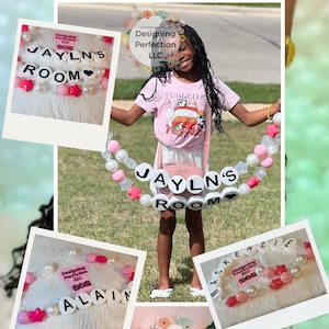 Puede incluir: Una ni&ntilde;a sostiene un gran brazalete de cuentas rosa y blanco con las palabras "JAYLN'S ROOM" escritas en letras blancas. El brazalete est&aacute; decorado con cuentas rosa y blanco, estrellas y corazones. La ni&ntilde;a lleva una camiseta rosa con las palabras "Fueled by VIBES" impresas en ella. La imagen tambi&eacute;n muestra otros brazaletes con diferentes nombres, incluyendo "ALAIN" y "MACKENZIE". La imagen incluye el texto "Designing Perfection LLC" y la direcci&oacute;n del sitio web "www.designingperfectionllc.com".