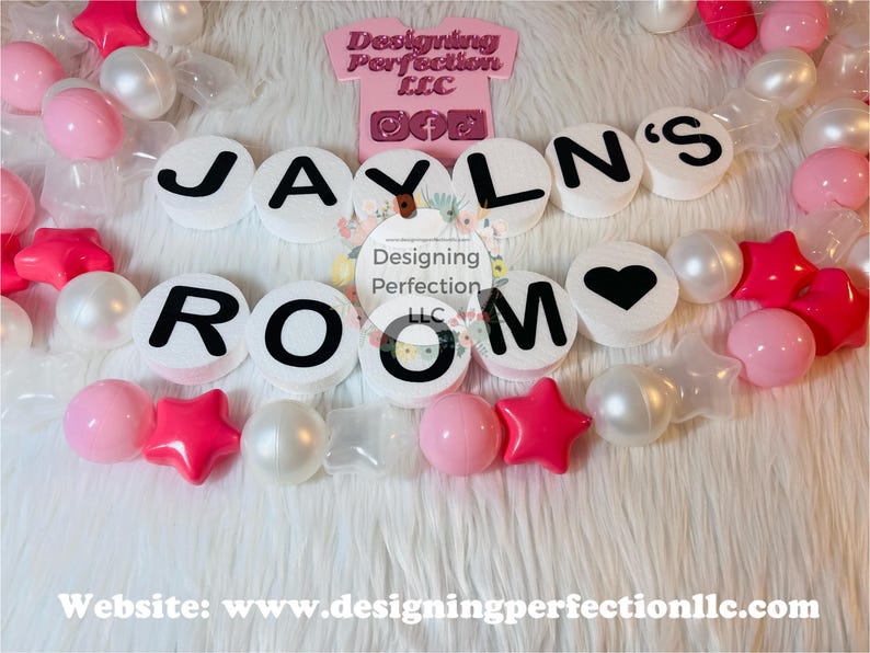 Puede incluir: Letras decorativas blancas y rosas que deletrean "JAYLN'S ROOM" con una letra "O" en forma de coraz&oacute;n. Las letras est&aacute;n rodeadas de cuentas blancas y rosas.