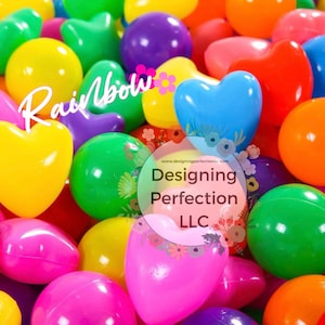 Puede incluir: Un mont&oacute;n grande de bolas de pl&aacute;stico de colores en forma de coraz&oacute;n y redondas. Las bolas son de varios tonos de rojo, naranja, amarillo, verde, azul, morado y rosa. El texto "Rainbow" est&aacute; escrito en blanco sobre una bola amarilla. El texto "Designing Perfection LLC" est&aacute; escrito en blanco sobre un c&iacute;rculo con un dise&ntilde;o floral.