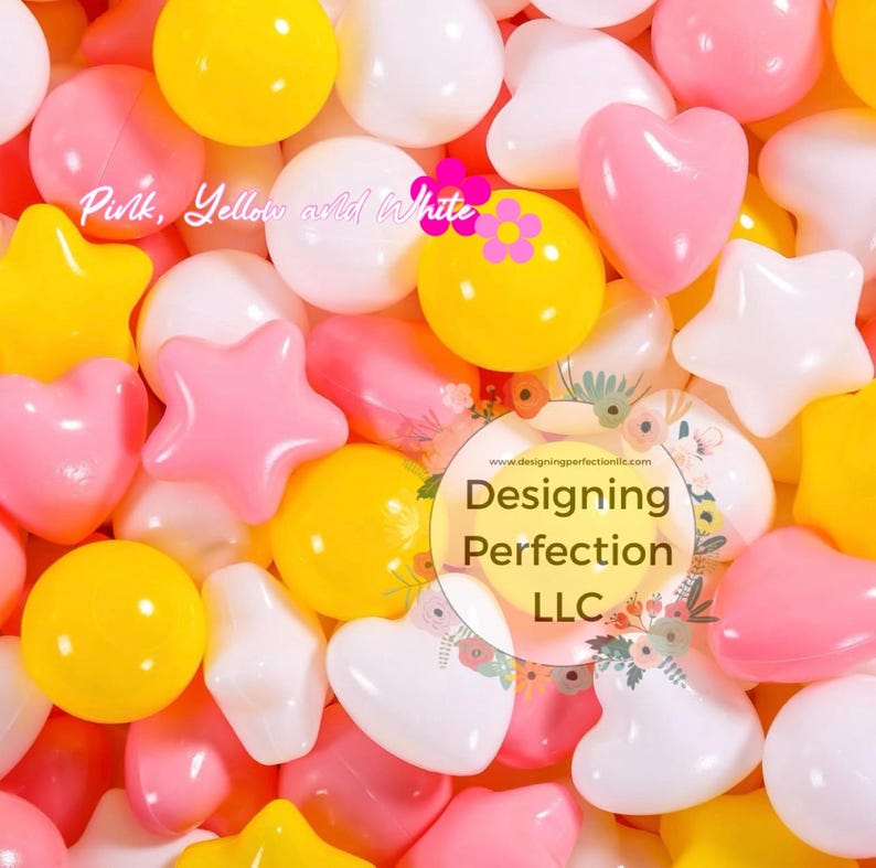 Puede incluir: Primer plano de un mont&oacute;n de juguetes de pl&aacute;stico de colores en forma de corazones, estrellas y c&iacute;rculos. Los juguetes son rosas, amarillos y blancos. El texto "Designing Perfection LLC" es visible en la imagen.