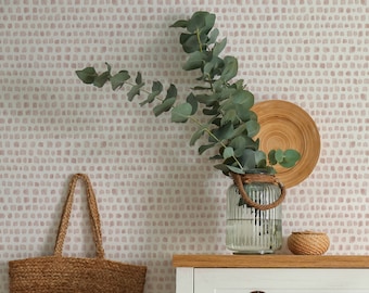 May include: White dresser with four drawers and brass handles. The dresser is against a wall with a pink and white patterned wallpaper. A woven basket bag hangs on the wall above the dresser. A vase with eucalyptus branches sits on top of the dresser. A wooden stool with a straw hat sits on the right side of the image. The text "West Coast Walls" is visible in the bottom right corner of the image.