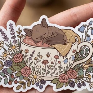 May include: A set of three ceramic mugs with a speckled, matte finish. The mugs are in shades of cream, light gray, and dark gray. Each mug has a simple, minimalist design, perfect for coffee or tea. The mugs are stacked on top of each other.