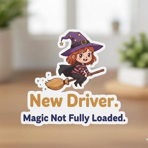 May include: A sticker featuring a cartoon witch riding a broom. The witch has red hair, a purple hat, and a black cape. The text on the sticker reads "New Driver. Magic Not Fully Loaded."