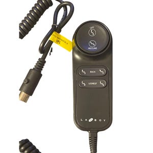 May include: A black La-Z-Boy remote control for a power recliner featuring a circular top button labeled LIFT and RECLINE, two rectangular buttons labeled BACK and LEGREST, and a coiled black power cord with a yellow tag reading Only connect to a 1PL.