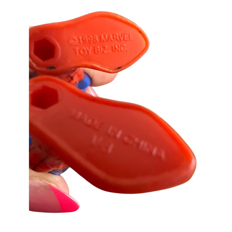 May include: Close-up of the bottom of a red and blue plastic action figure. The figure's feet are visible. The text "&copy;1993 MARVEL TOY BIZ, INC." is printed on the bottom of the figure's foot. The text "MADE IN CHINA" is printed on the bottom of the other foot.