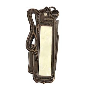 Könnte beinhalten: Eine bronzefarbene Gürtelschnalle in Form einer Golftasche mit einem rechteckigen Perlmutt-Inlay. Die Schnalle zeigt Golfschläger und ein Riemendesign. Das Gesamtdesign ist vintage und detailliert.