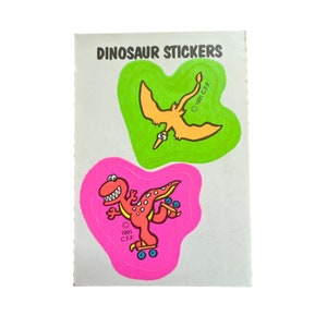 May include: A sheet of dinosaur stickers featuring a green and yellow pterodactyl and a pink dinosaur on roller skates. The text "DINOSAUR STICKERS" is at the top of the sheet. The copyright information "© 1981 C.F.F." is on the pterodactyl sticker and "© 1991 C.F.F." is on the dinosaur sticker.
