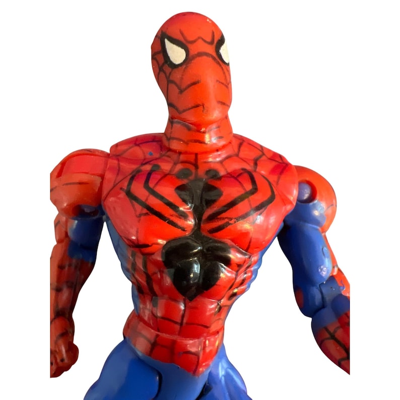 May include: A red and blue plastic action figure of Spider-Man. The figure has a detailed design with a black spider symbol on the chest.