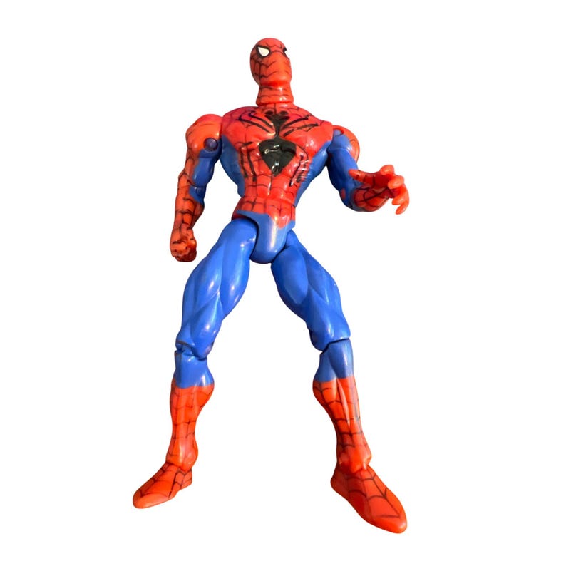 May include: A red and blue plastic action figure of Spiderman. The figure has a web design on its chest and is posed with one leg forward and one arm raised.