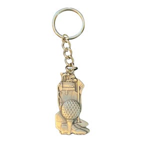 May include: Silver-colored golf-themed keychain. The keychain features a golf ball on a tee, a golf bag, and golf clubs. The keychain is attached to a chain and a key ring.