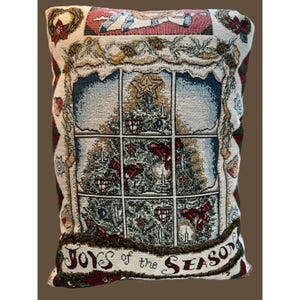 Peut inclure: Un oreiller de couleur crème avec un motif de tapisserie représentant un sapin de Noël avec des ornements et les mots "Joys of the Season".
